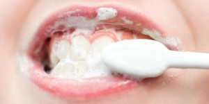 a kids mouth during teeth brushing, macro